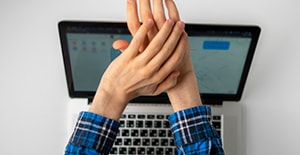 man covering webcam with hands